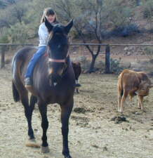 Diane (6) auf Coco Puff, daneben das Kalb Cecil